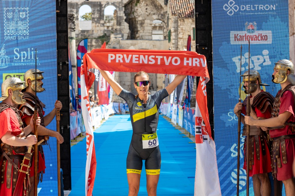 Athlete breaking the finish tape at Split TRI with Diocletian’s Palace behind